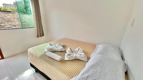 a bed with towels on top of it with a window at Pousada São Miguel Beach Beira Mar in Penha