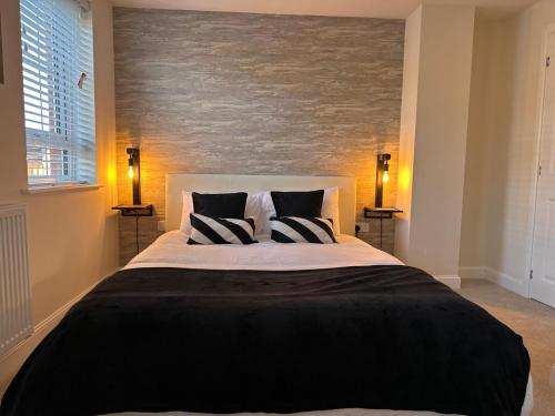 a bedroom with a large bed with two pillows at Olive Tree House in Edwinstowe