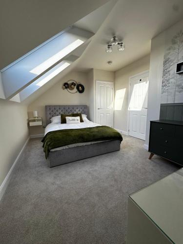 a bedroom with a large bed and a skylight at Olive Tree House in Edwinstowe
