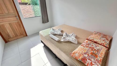 a bed with bows on it in a room at Pousada São Miguel Beach Beira Mar in Penha