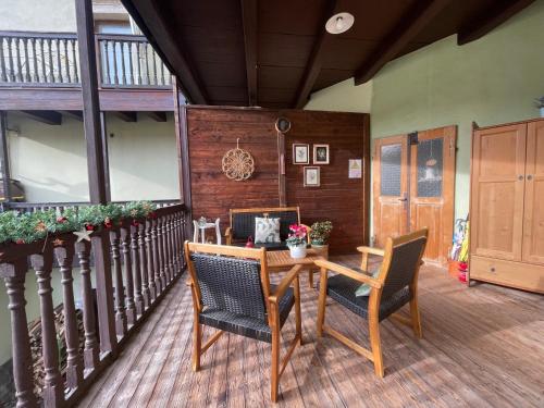 una veranda con tavolo e sedie in legno di Casetta alla fontana a Villa Lagarina
