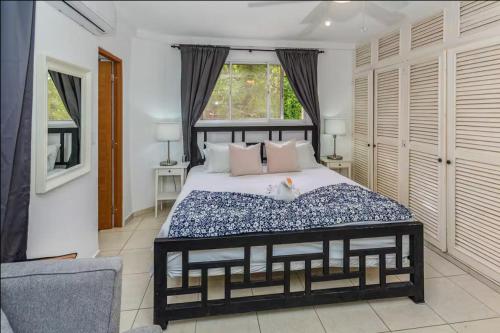 a bedroom with a large bed and a window at El Neptuno Residencial, Sosua in Sosúa