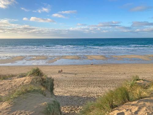 a beach with people on the sand and the ocean at Bora House in Newquay