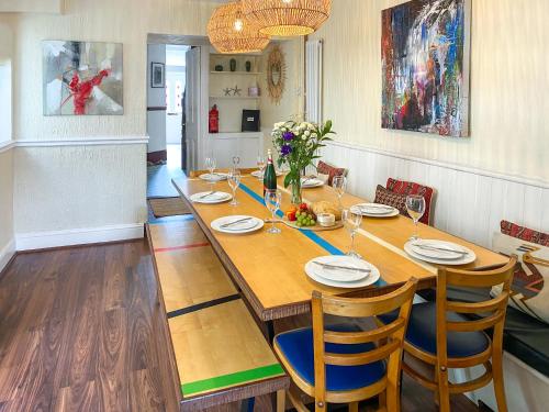 a dining room with a wooden table and chairs at Bora House in Newquay