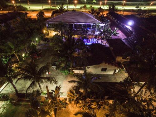 an aerial view of a building with palm trees at night at Apart Hotel Porto Kanoas in Bertioga