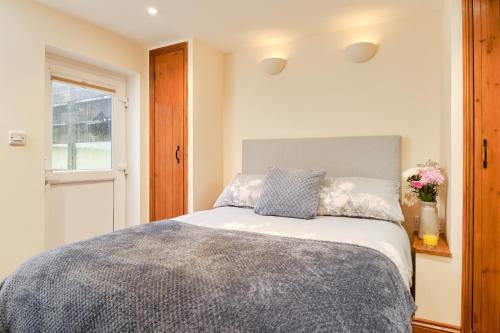 een slaapkamer met een bed en een raam bij Finest Retreats - The Barn at St Just in St Just