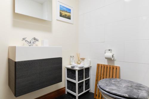 een eetkamer met een tafel en een wastafel bij Finest Retreats - The Barn at St Just in St Just