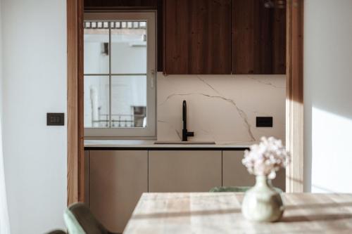 une cuisine avec une table avec un vase de fleurs dans l'établissement Appartamenti Olympic, à Santa Cristina Valgardena