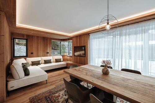 un salon avec une table et un canapé dans l'établissement Appartamenti Olympic, à Santa Cristina Valgardena