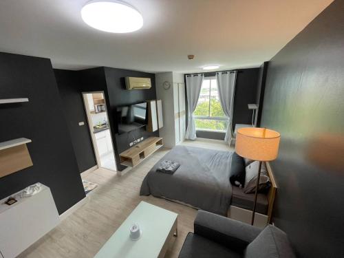 een kleine slaapkamer met een bed en een bank bij studio123 at Changwattana in Ban Bang Phang