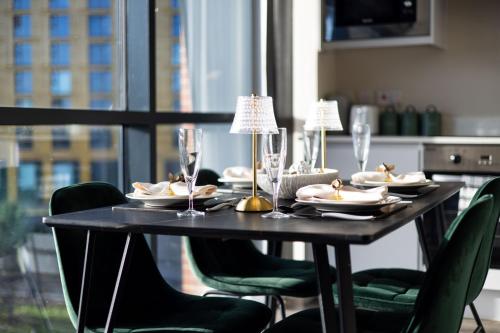 a black table with plates and glasses and chairs at Central Leeds Apartment, Walk Everywhere , City Views in Central Station