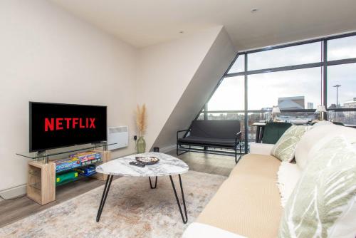 a living room with a couch and a tv at Central Leeds Apartment, Walk Everywhere , City Views in Central Station
