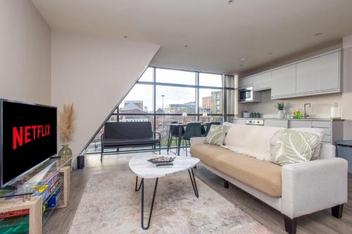 a living room with a couch and a tv at Central Leeds Apartment, Walk Everywhere , City Views in Central Station