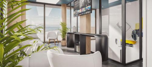 Hotel Ben Marsalforn Affiliated by Meliá في مارسالفورن: غرفة معيشة مع تلفزيون وكرسي أبيض