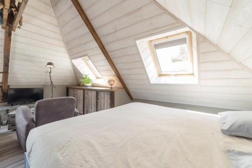 una camera da letto con letto e TV in mansarda di Ti Melen a Carnac