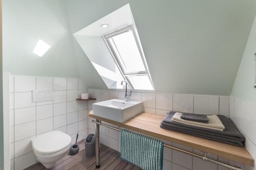 un bagno con un water, un lavandino e una finestra di Ti Melen a Carnac