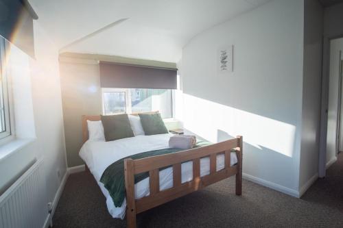a small bedroom with a bed and a window at Spacious Canalside Cottage - Games Room - Dog Walks in Loughborough