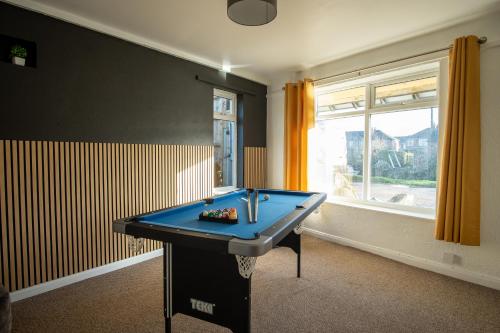 a blue ping pong table in a room with a window at Spacious Canalside Cottage - Games Room - Dog Walks in Loughborough