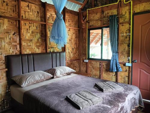 een slaapkamer met een bed met twee handdoeken erop bij Bansuan Lanta Maikaew in Koh Lanta