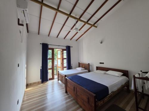 Aruna homestay في بولوناروا: غرفة نوم بها سريرين في الغرفة