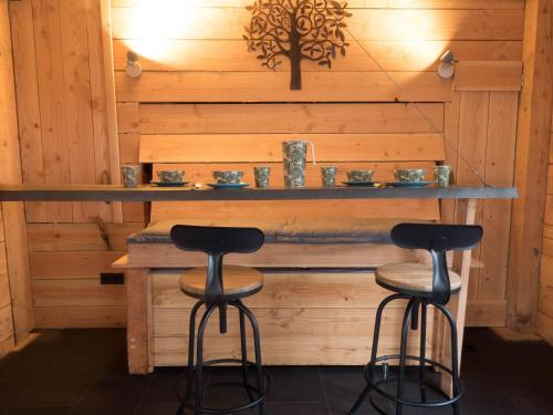 two bar stools in a room with wooden walls at Boomhut XXL in Hoogersmilde