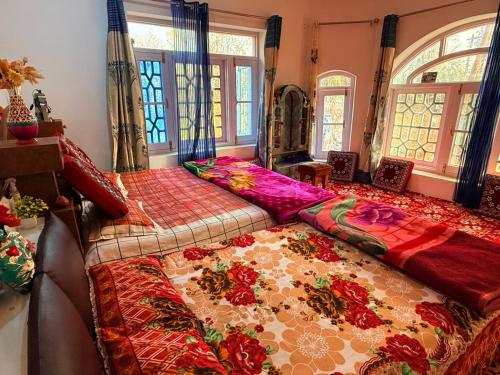 a bedroom with a large bed with colorful blankets at Habib Guest House GULMARG 11 in Tangmarg