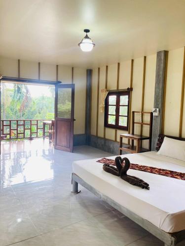 a room with two beds and a door to a balcony at Pizza classic resort kohjum in Ban Ko Phrao