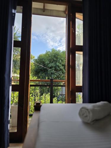 a bedroom with a window with a view of a tree at Aruna homestay in Polonnaruwa