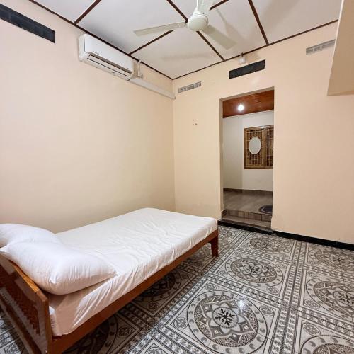 een kamer met een bed en een tapijt bij Jaffna Stay Guest House in Jaffna
