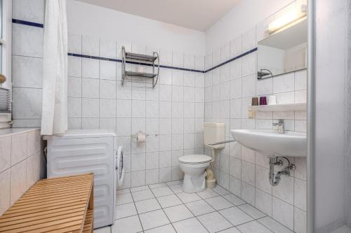 a white bathroom with a sink and a toilet at Reihenendhaus Celebes in Dierhagen