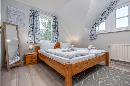 a bedroom with a bed with white sheets and a mirror at Reihenendhaus Celebes in Dierhagen