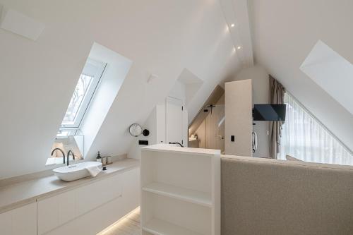 a white bathroom with a sink and a staircase at Sylter Strandholz in Westerland