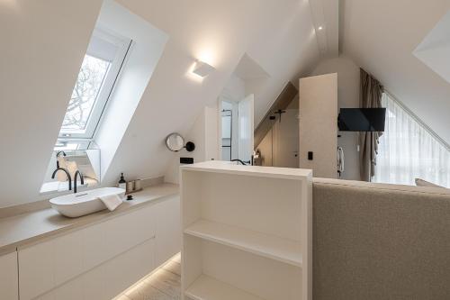 een witte badkamer met een wastafel en een spiegel bij Sylter Strandholz in Westerland