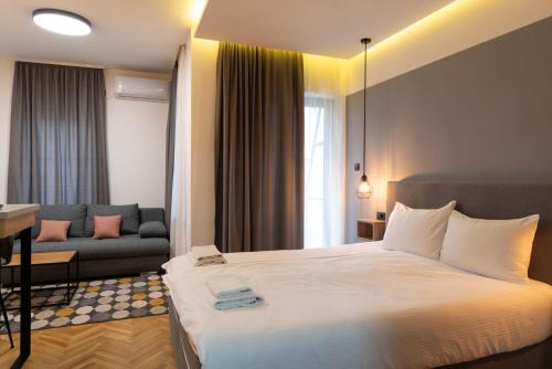 a hotel room with a bed and a couch at Apartmani Central & Free parking in Vrnjačka Banja