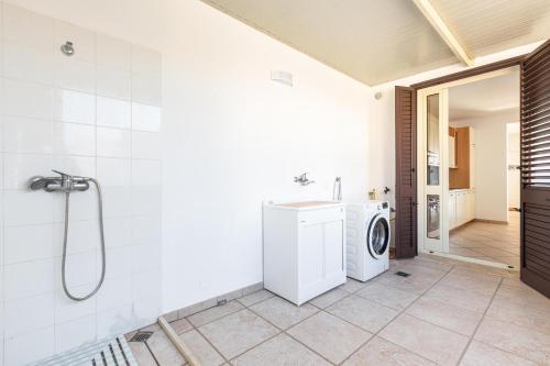 een badkamer met een wasmachine en een wasmachine en droger bij Casa Agnese by BarbarHouse in Leuca