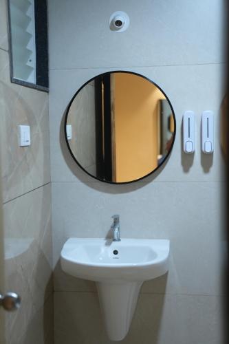 Sasya Elegance - A Boutique Hotel في Lingampalli: حمام مع حوض ومرآة على الحائط