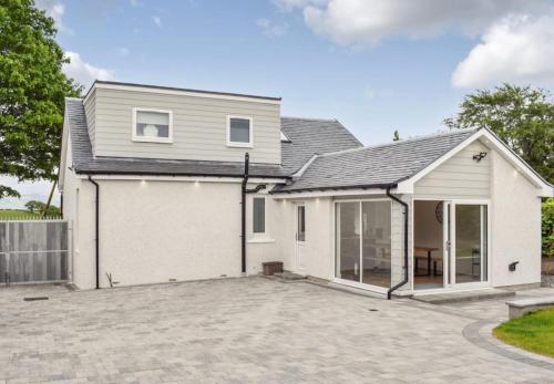 a house with a large driveway in front of it at 5 Bed cottage with Hot tub in Bannockburn