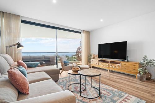 a living room with a couch and a flat screen tv at Peace Haven III in Câmara de Lobos