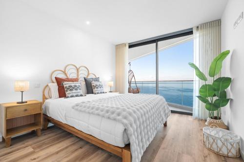 een slaapkamer met een groot bed en een groot raam bij Peace Haven III in Câmara de Lobos