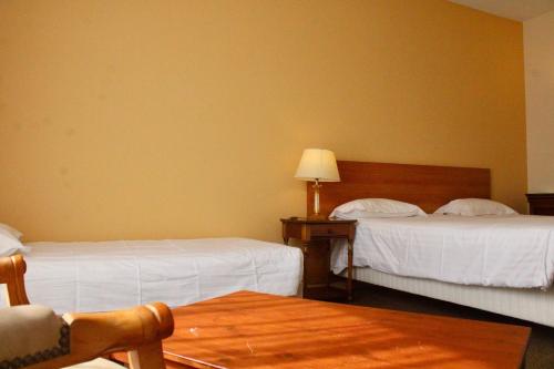 una habitación de hotel con dos camas y una mesa en Hôtel de la Marine, en Saint-Herblain