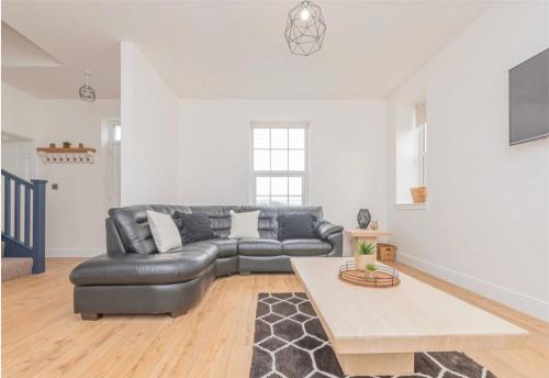 a living room with a leather couch and a table at 5 Bed cottage with Hot tub in Bannockburn