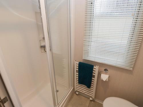 a bathroom with a shower and a blue towel at Woodland View in Skipton