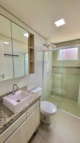 ein Badezimmer mit Waschbecken, Toilette und Dusche in der Unterkunft Dubai Thermas Piratuba 406 in Piratuba