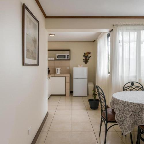 a kitchen and dining room with a table and chairs at Casa Cafetal Aeropuerto in Alajuela