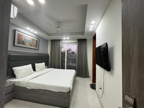 a bedroom with a bed and a television in it at LR Suites Near Huda City Centre in Gurgaon
