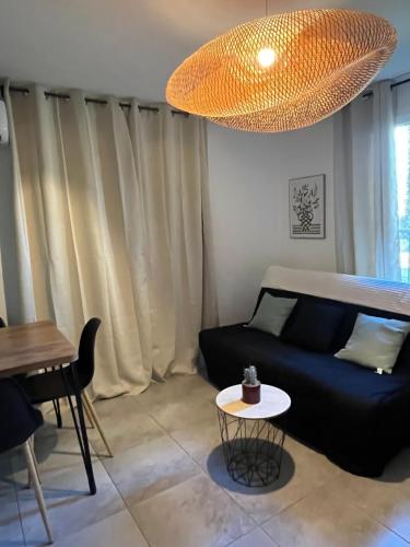 een woonkamer met een blauwe bank en een tafel bij Résidence Luna, Saint-Cyprien in Porto-Vecchio