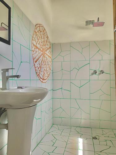 Un baño con lavabo y azulejos azules. en Chipatso, en Cape Maclear