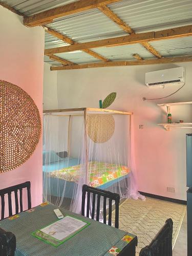 Una habitación con una mesa y una cama dentro. en Chipatso, en Cape Maclear