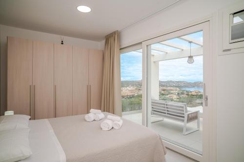 a bedroom with a bed and a large window at Smeraldo Apartment in Palau