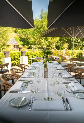 a long table with plates and wine glasses at Boutique Hotel Slenaker Vallei - Buitengewoongenieten in Slenaken